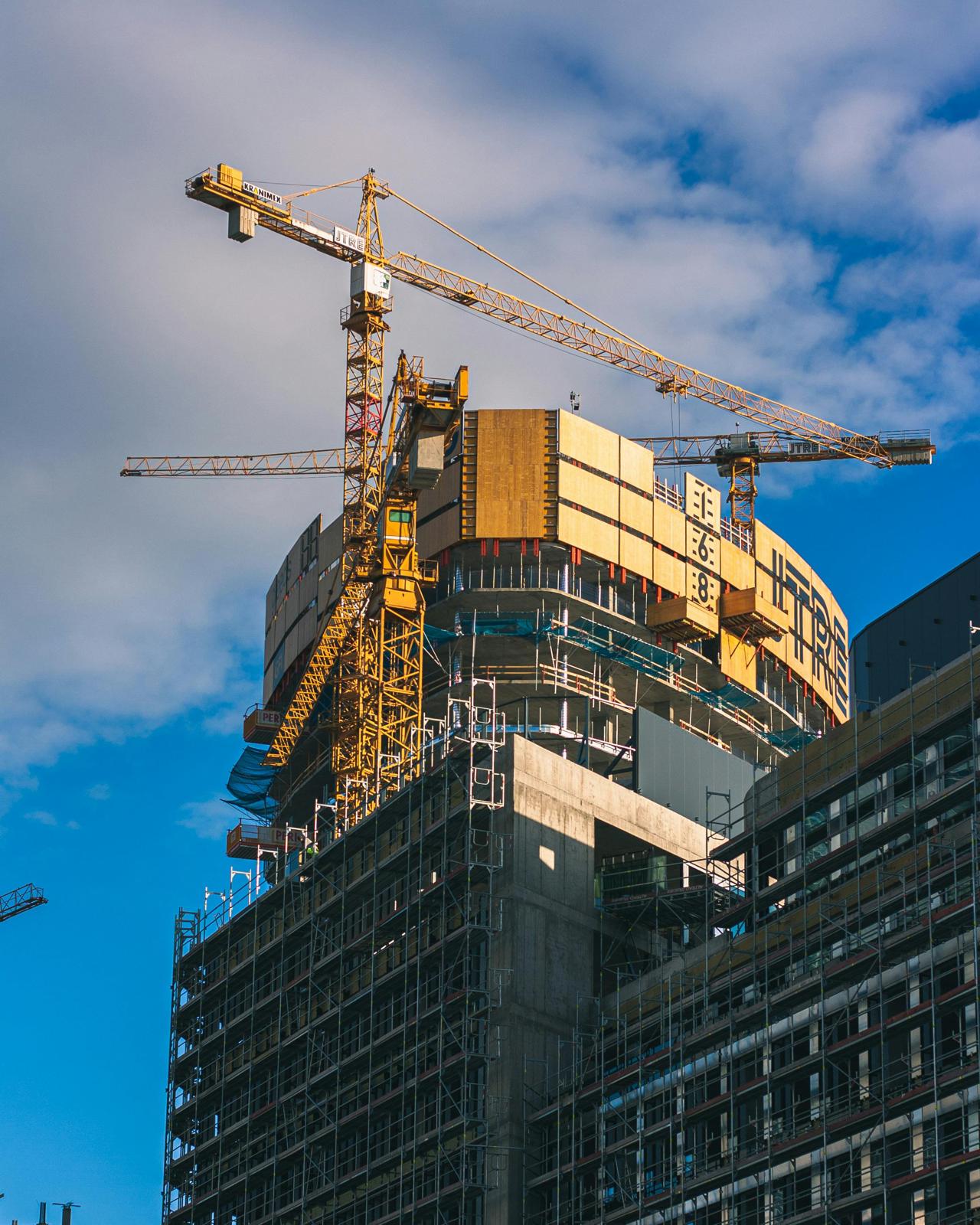 Bouwproject met hijskranen en een gebouw in aanbouw
